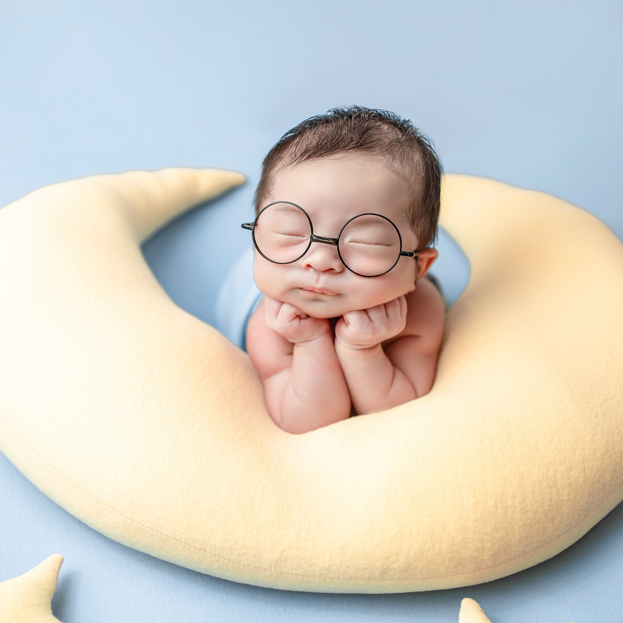 Baby mit Brille schlafend auf Mond